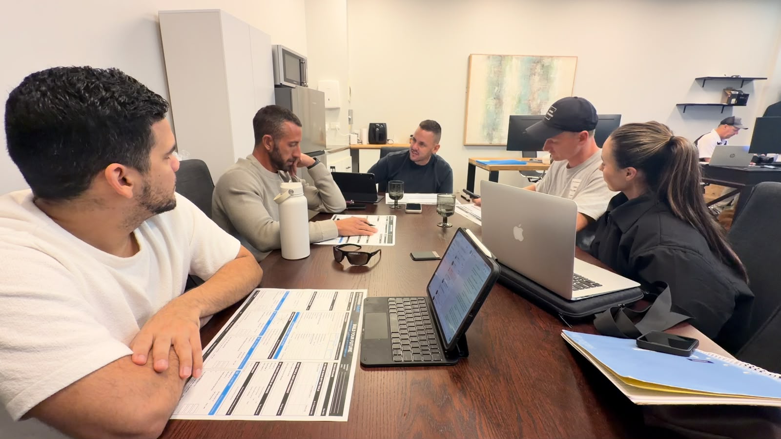 Trade business owners working through their printed implementation plans around the office table