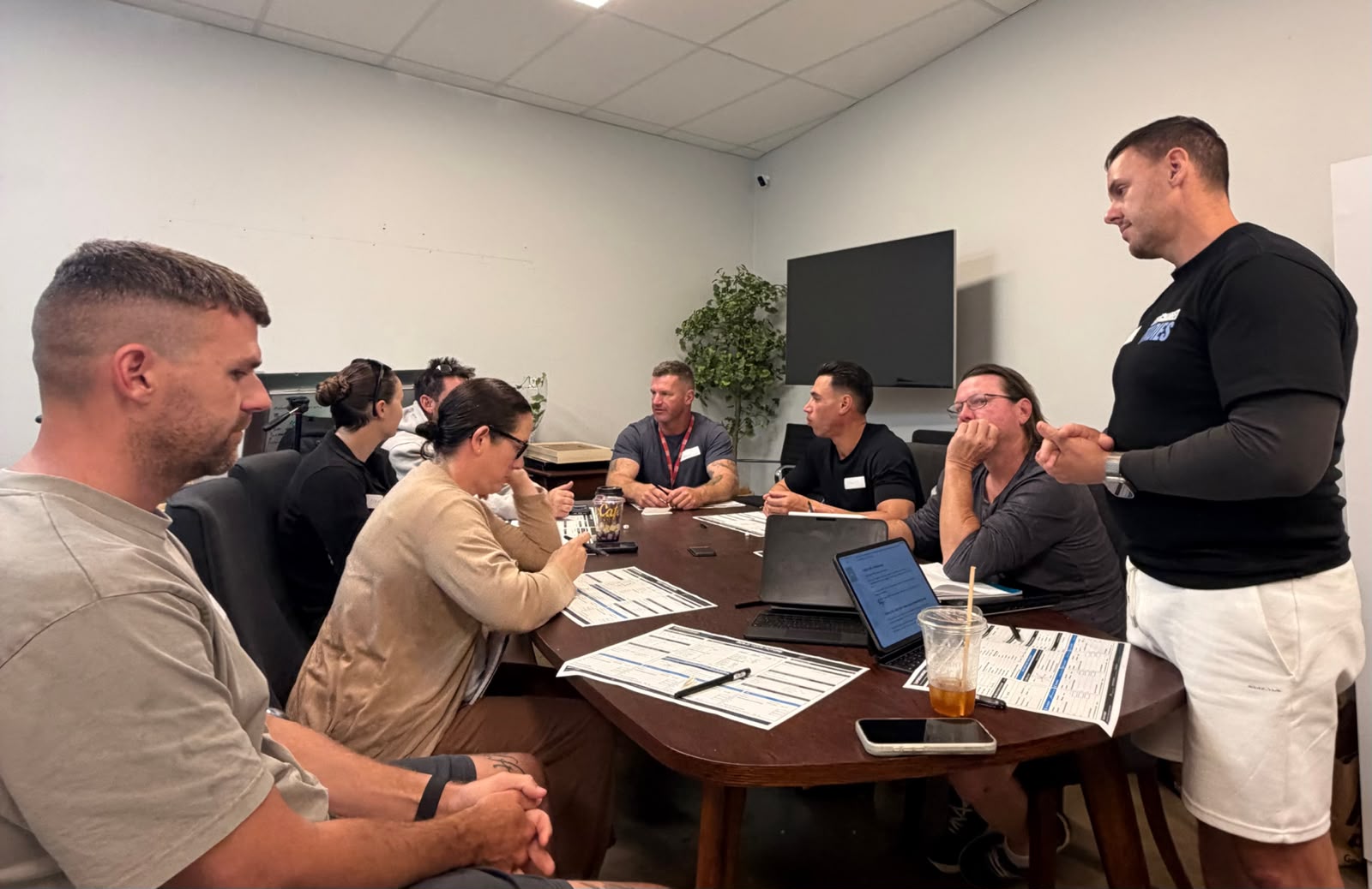 Trade business owners around the table at the Burleigh office, working through their planning sheets while Jason facilitates